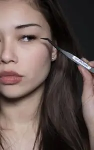 Model brengt Xynxira cluster lashes aan met de tweezer