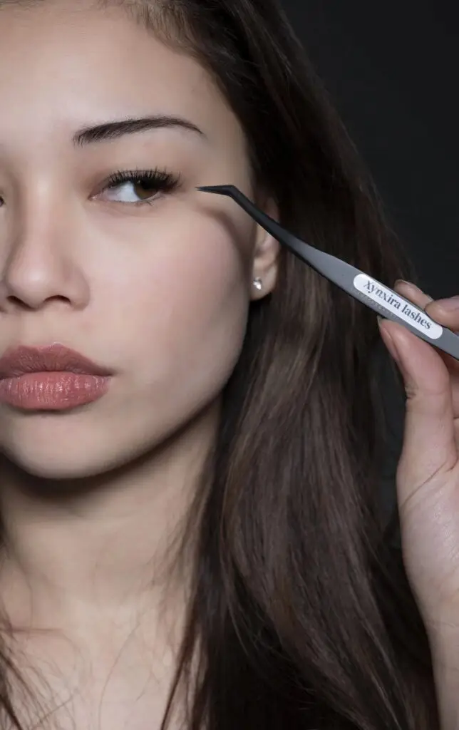 Model brengt Xynxira cluster lashes aan met de tweezer