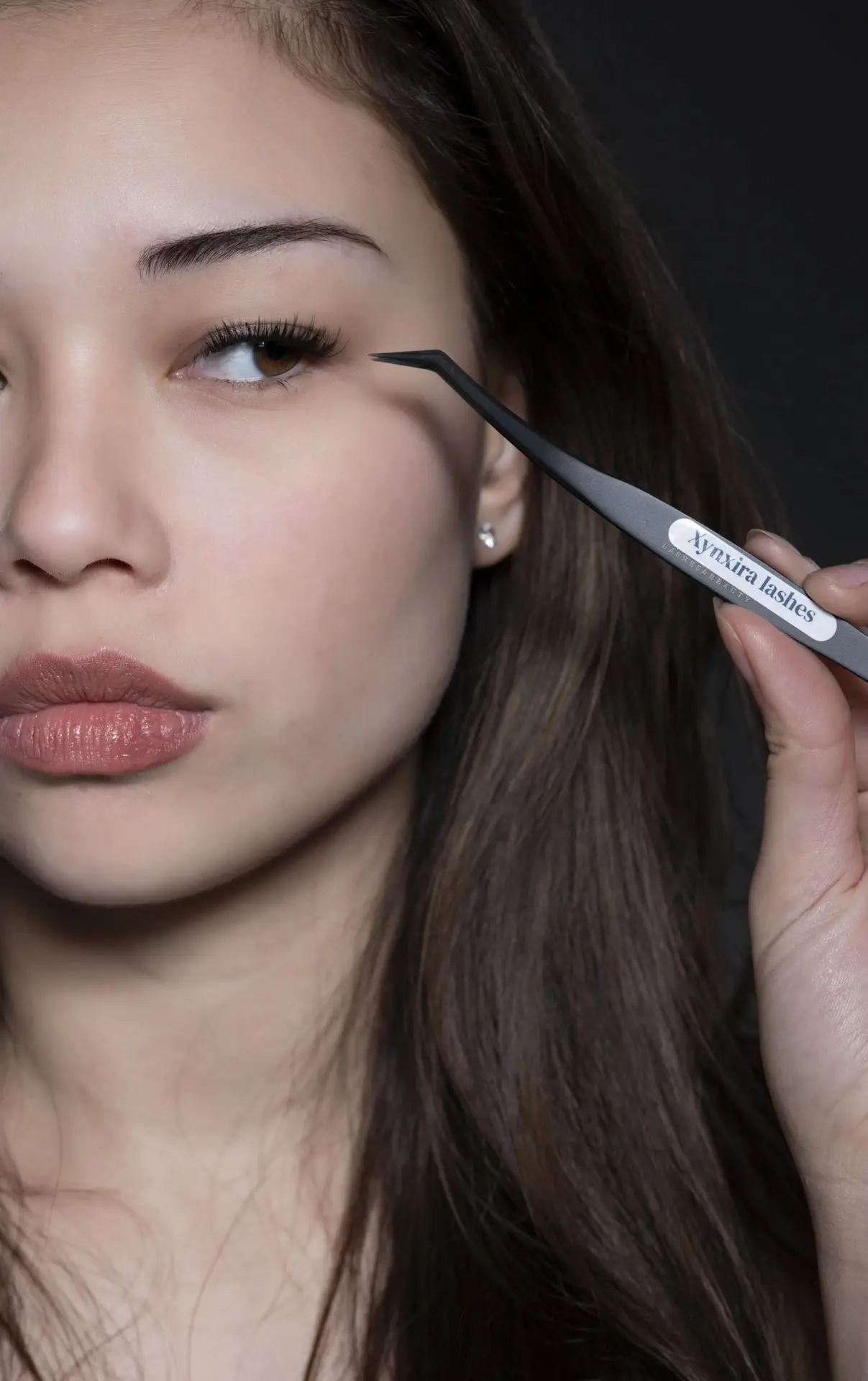 Model brengt Xynxira cluster lashes aan met de tweezer