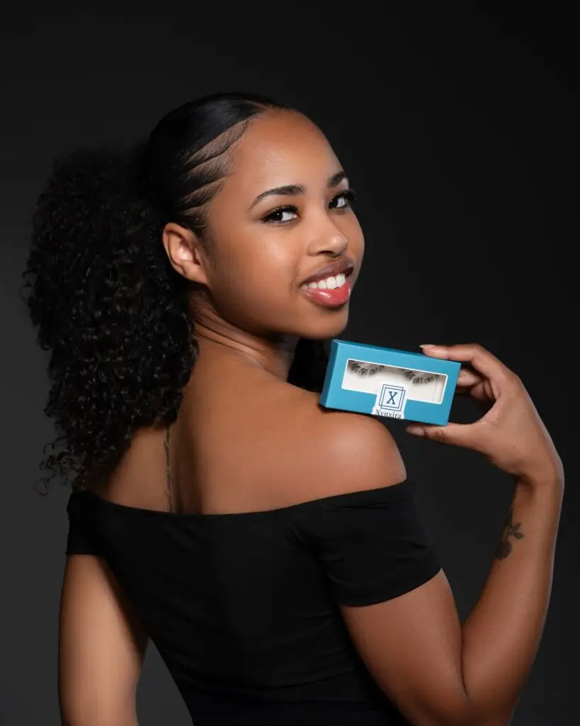 Lachend model met Xynxira lashes verpakking